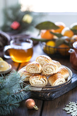 Oriental dessert gata with a cup of tea and tangerines on a wooden table. Selective focus. copy space