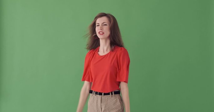 Portrait of angry young woman shouting in outrage over green background
