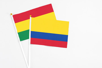 Colombia and Bolivia stick flags on white background. High quality fabric, miniature national flag. Peaceful global concept.White floor for copy space.