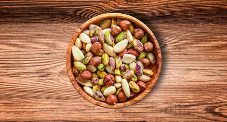 Nuts Mixed on wooden board.Variety of Walnuts, Almonds, Hazelnuts, Cashews, Pistachios. Concept of Healthy raw food selective focus.