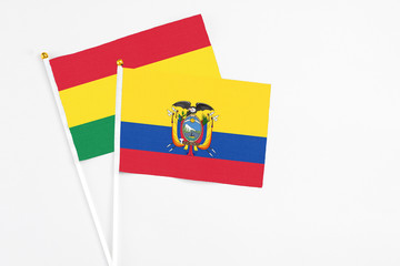Fototapeta premium Ecuador and Bolivia stick flags on white background. High quality fabric, miniature national flag. Peaceful global concept.White floor for copy space.