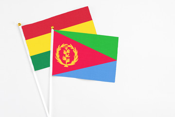 Eritrea and Bolivia stick flags on white background. High quality fabric, miniature national flag. Peaceful global concept.White floor for copy space.
