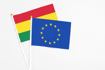 European Union and Bolivia stick flags on white background. High quality fabric, miniature national flag. Peaceful global concept.White floor for copy space.