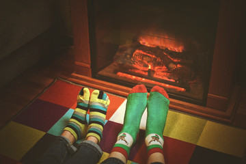 Feet in wool socks near fireplace in winter time