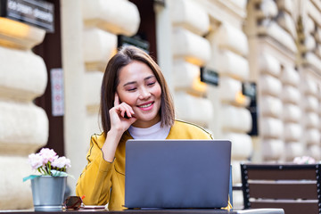 Young Asian businesswoman is working in a cafeteria in her break. Woman taking a break. Enjoying work from coffee shop. Doing Business From coffee shop
