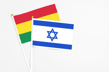 Israel and Bolivia stick flags on white background. High quality fabric, miniature national flag. Peaceful global concept.White floor for copy space.