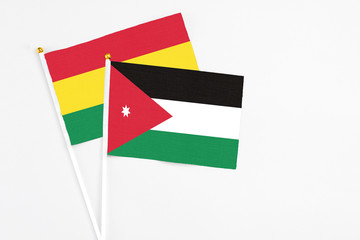 Jordan and Bolivia stick flags on white background. High quality fabric, miniature national flag. Peaceful global concept.White floor for copy space.