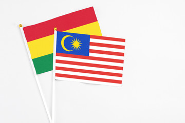 Malaysia and Bolivia stick flags on white background. High quality fabric, miniature national flag. Peaceful global concept.White floor for copy space.