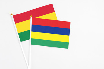 Mauritius and Bolivia stick flags on white background. High quality fabric, miniature national flag. Peaceful global concept.White floor for copy space.