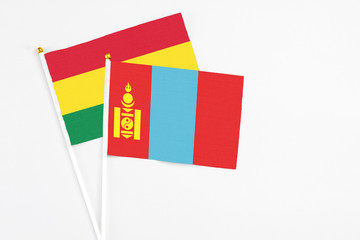 Mongolia and Bolivia stick flags on white background. High quality fabric, miniature national flag. Peaceful global concept.White floor for copy space.
