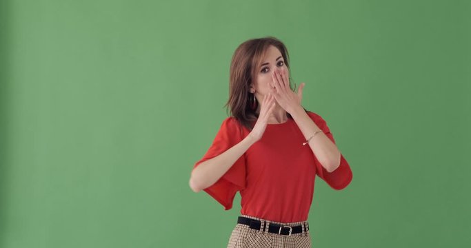 Young woman with disgusted expression repulsing something over green background