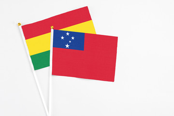 Samoa and Bolivia stick flags on white background. High quality fabric, miniature national flag. Peaceful global concept.White floor for copy space.
