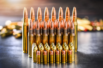 Various kind of bullets or ammonution on dark stone table. Bullet pile in war ammo background. Magazines, rounds and military technology. Banner or panorama guns photo.. - obrazy, fototapety, plakaty