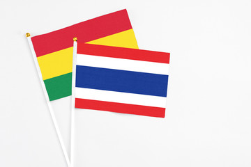 Thailand and Bolivia stick flags on white background. High quality fabric, miniature national flag. Peaceful global concept.White floor for copy space.