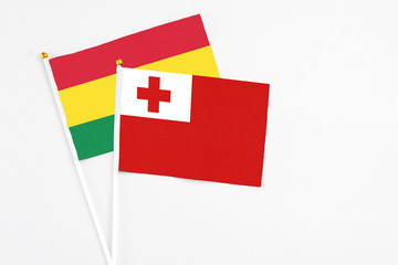 Tonga and Bolivia stick flags on white background. High quality fabric, miniature national flag. Peaceful global concept.White floor for copy space.