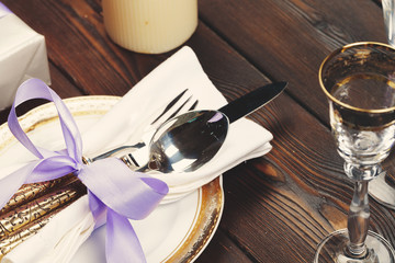 Holiday table setting on wooden table in lilac colors