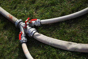 Fototapeta na wymiar Fire brigade four way valve for water hoses on the ground