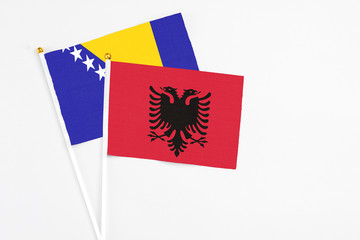 Albania and Bosnia Herzegovina stick flags on white background. High quality fabric, miniature national flag. Peaceful global concept.White floor for copy space.