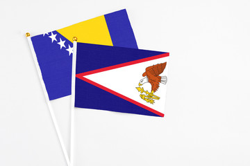American Samoa and Bosnia Herzegovina stick flags on white background. High quality fabric, miniature national flag. Peaceful global concept.White floor for copy space.