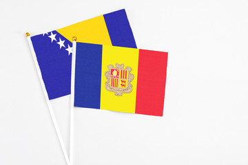 Andorra and Bosnia Herzegovina stick flags on white background. High quality fabric, miniature national flag. Peaceful global concept.White floor for copy space.