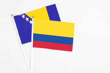 Colombia and Bosnia Herzegovina stick flags on white background. High quality fabric, miniature national flag. Peaceful global concept.White floor for copy space.
