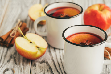 White cups of glint wine on wooden table close up