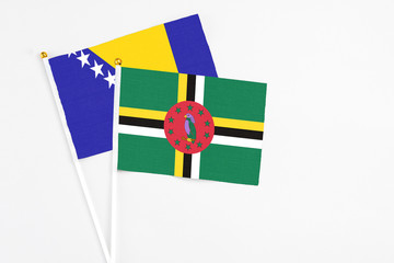 Dominica and Bosnia Herzegovina stick flags on white background. High quality fabric, miniature...