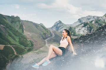 Sport woman relaxing on mountain cliff above the clouds. Alone travel healthy lifestyle. Healthy...