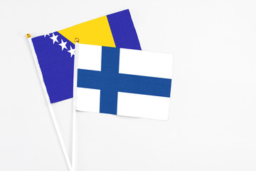 Finland and Bosnia Herzegovina stick flags on white background. High quality fabric, miniature...