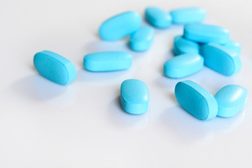 blue pills on white background close-up