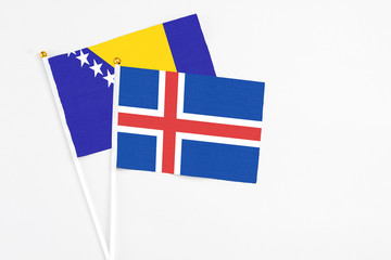 Iceland and Bosnia Herzegovina stick flags on white background. High quality fabric, miniature...