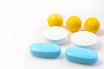 blue, yellow pills on a white background close-up