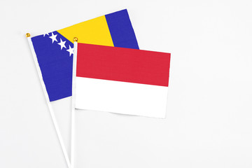 Indonesia and Bosnia Herzegovina stick flags on white background. High quality fabric, miniature national flag. Peaceful global concept.White floor for copy space.