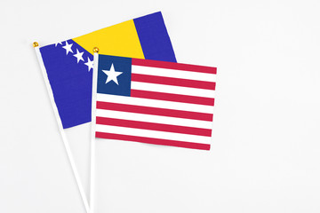 Liberia and Bosnia Herzegovina stick flags on white background. High quality fabric, miniature national flag. Peaceful global concept.White floor for copy space.