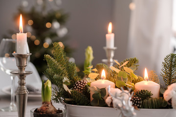 fragments of Christmas decor, cones, candles on the background of a decorated Christmas tree