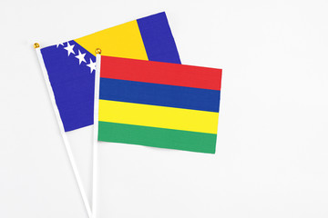 Mauritius and Bosnia Herzegovina stick flags on white background. High quality fabric, miniature national flag. Peaceful global concept.White floor for copy space.