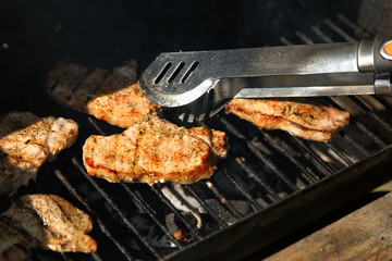 Grilling steaks on barbecue grill.Flaming charcoal grill with open fire. Concept of summer grilling, barbecue, bbq and party. Preparing homemade meal.