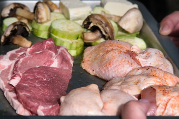 Raw meat and chicken prepared to be grilled.Outdoor Picnic.Set of uncooked sliced pork, chicken and mushrooms for Barbecue. 