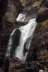 Fototapeta na wymiar waterfall through a hole in the mountain