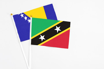 Saint Kitts And Nevis and Bosnia Herzegovina stick flags on white background. High quality fabric,...