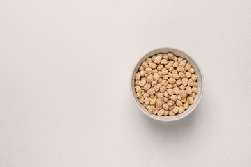 Bowl with chickpea on a light textured background.