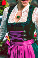 Ausschnitt eines gr&uuml;nen Designer Dirndl aus Samt mit lila Sch&uuml;rze und wei&szlig;er Spitzenbluse