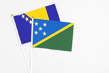 Solomon Islands and Bosnia Herzegovina stick flags on white background. High quality fabric,...