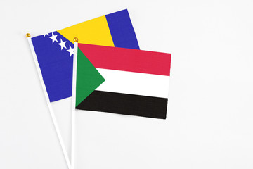 Sudan and Bosnia Herzegovina stick flags on white background. High quality fabric, miniature national flag. Peaceful global concept.White floor for copy space.
