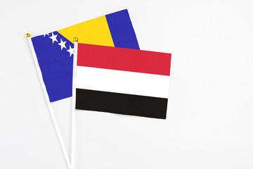 Yemen and Bosnia Herzegovina stick flags on white background. High quality fabric, miniature national flag. Peaceful global concept.White floor for copy space.