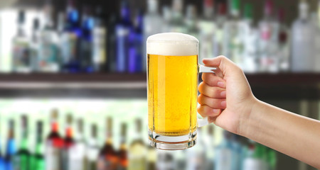 Glass of a beer in hand isolated