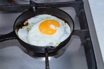 Frying organic egg on frying pan. Environmentally friendly eating.