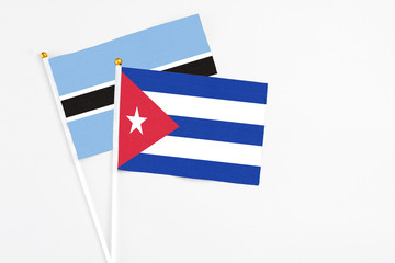 Cuba and Botswana stick flags on white background. High quality fabric, miniature national flag. Peaceful global concept.White floor for copy space.