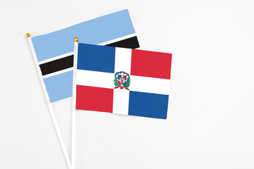 Dominican Republic and Botswana stick flags on white background. High quality fabric, miniature...