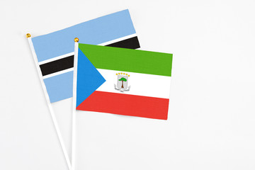 Equatorial Guinea and Botswana stick flags on white background. High quality fabric, miniature national flag. Peaceful global concept.White floor for copy space.